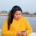 Portrait fat Asian woman long black hair wearing yellow shirt Are using mobile phone or smartphone work with serious and serious face and expression Inside park In evening hours sunset day